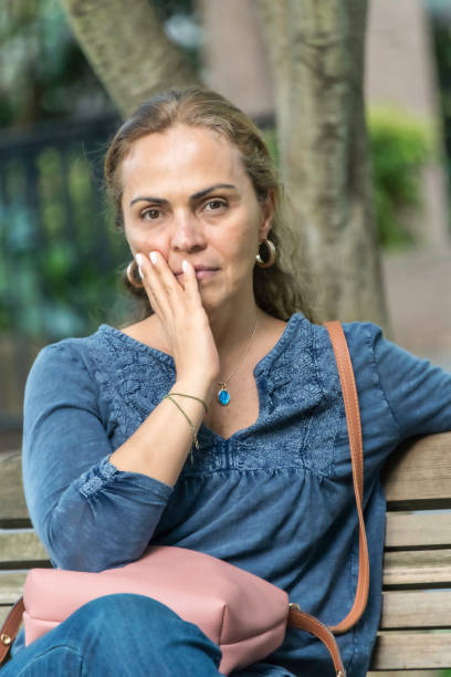 istock Hispanic woman looking away sitting in a bench 961020614