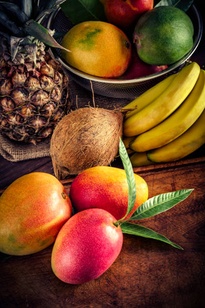 istock Close-up of assorted tropical fruits on cutting board in a rustic kitchen. Natural lighting 961024828