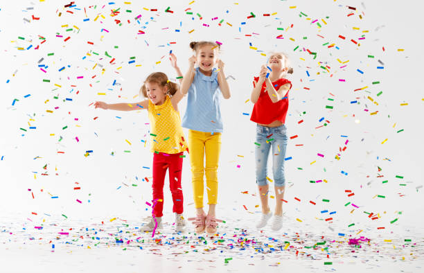 istock happy children on holidays  jumping in multicolored confetti on white 961030756