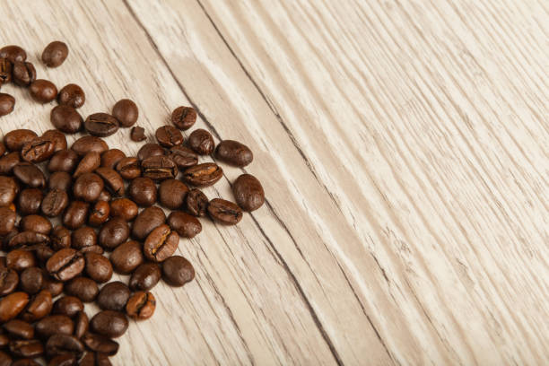 istock Grains of coffee on a wooden background in large quantities 961034536