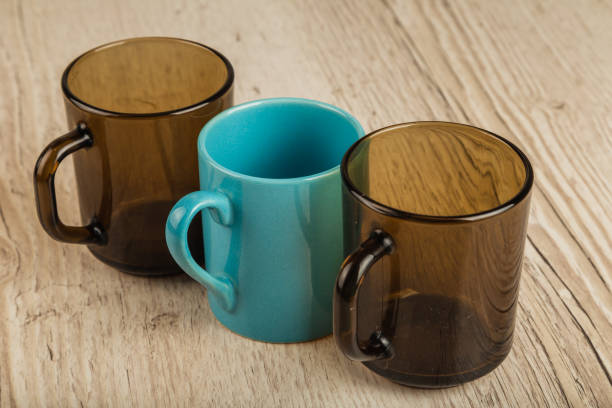istock Three cups on a wooden background in different positions 961035964