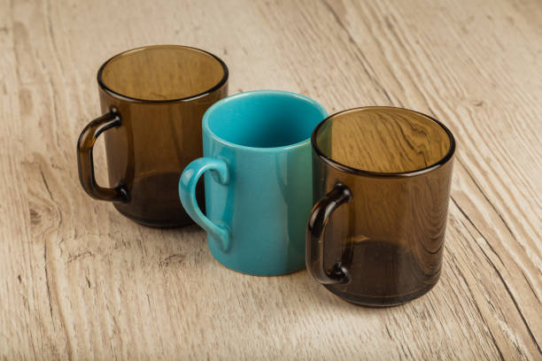 istock Three cups on a wooden background in different positions 961035996
