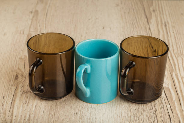 istock Three cups on a wooden background in different positions 961036068