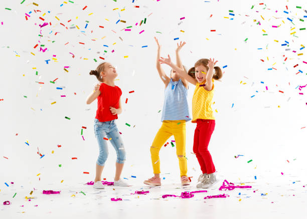 istock happy children on holidays  jumping in multicolored confetti on white 961038818