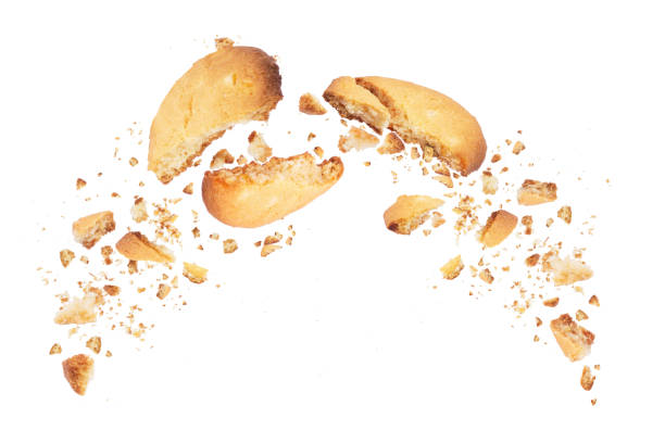 Biscuits broken into two halves with falling crumbs down, isolated on white background Biscuits broken into two halves with falling crumbs down, isolated on white background crumb stock pictures, royalty-free photos & images