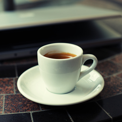 A single shot of espresso in a porcelain cup on a table