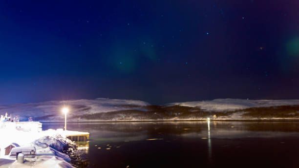 Winter aurora borealis in the Finland sky with mountain silhouettes, North Pole stock photo