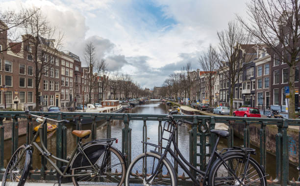 Canals of Amsterdam area and waterfront in Holland, The Netherlands. Cloudy day during winter season in Amsterdam, The Netherlands. This modern city attract every year thousands of tourists. stock photo
