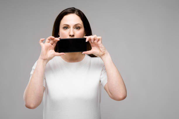 istock Young woman presenting telephone 961077874