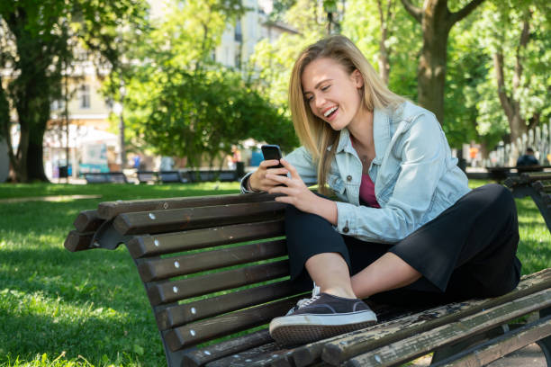 istock Young woman texting in the park 961081214