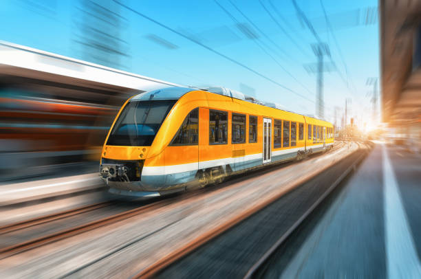 istock High speed orange train in motion on the railway station at bright day. Modern intercity train with motion blur effect on the railway platform. Industrial. Passenger commuter train on railroad. Travel 961081796