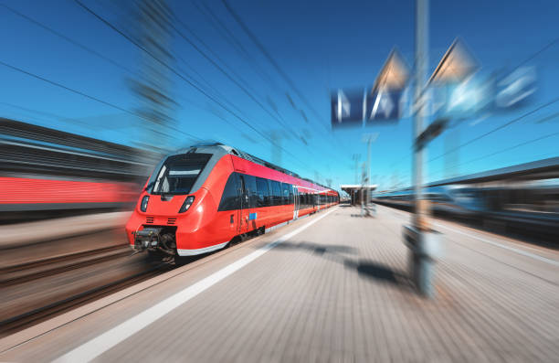 istock High speed red train in motion on the railway station at bright day. Modern intercity train with motion blur effect on the railway platform. Industrial. Passenger commuter train on railroad. Travel 961081810