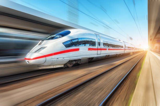 White modern high speed train in motion on railway station at sunset. Passenger train on railroad track with motion blur effect in Europe. Railway platform. Industrial landscape. Railway tourism White modern high speed train in motion on railway station at sunset. Passenger train on railroad track with motion blur effect in Europe. Railway platform. Industrial landscape. Railway tourism intercity train photos stock pictures, royalty-free photos & images