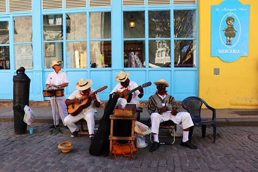 Cuban Musicians playing in front of a vibrant market in Havana