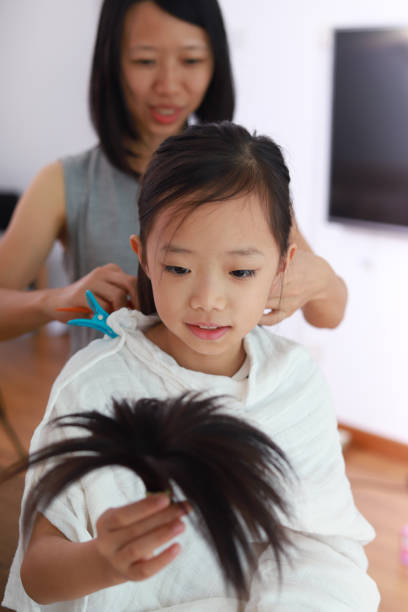 istock Mother giving daughter haircut 961106244