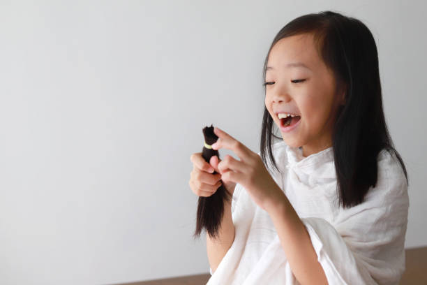 istock Girl holding up her freshly cut ponytail 961109030
