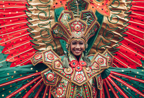 Asian woman in traditional Indonesian costume of Garuda performing ritual dancing ceremony smiling