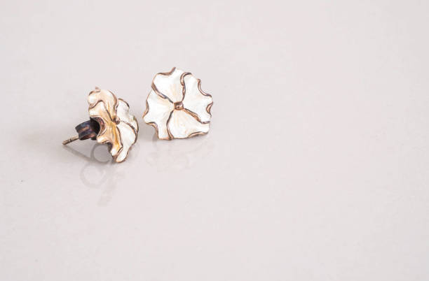 istock Closeup old white flower earring on blurred marble floor background 961126606