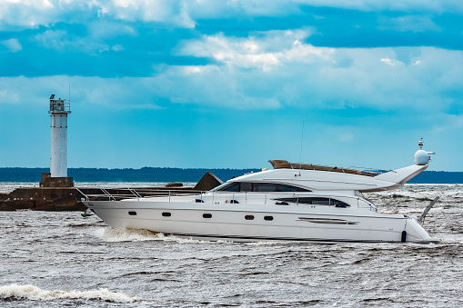 White speed boat moving fast to the Baltic sea. Water sport