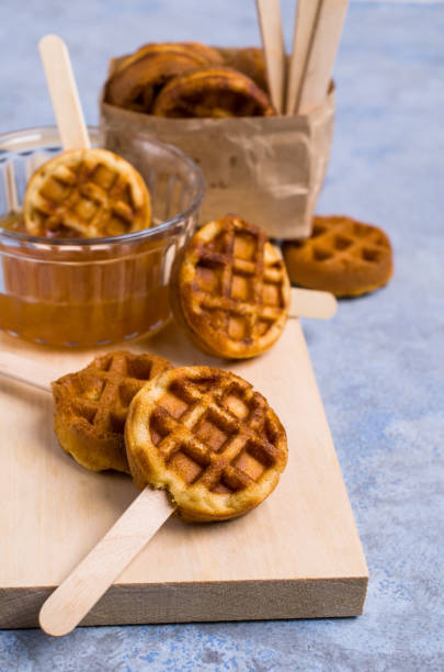 Round fried waffles Round fried waffles on a stick with jam. Selective focus. biscuit quick bread photos stock pictures, royalty-free photos & images