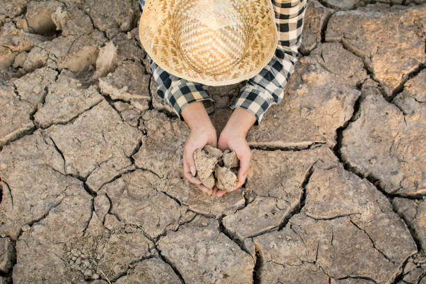 istock Asian man on cracked dry ground, concept drought and crisis environment 961166800