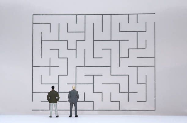 istock The back of two miniature men watching the maze. 961167498