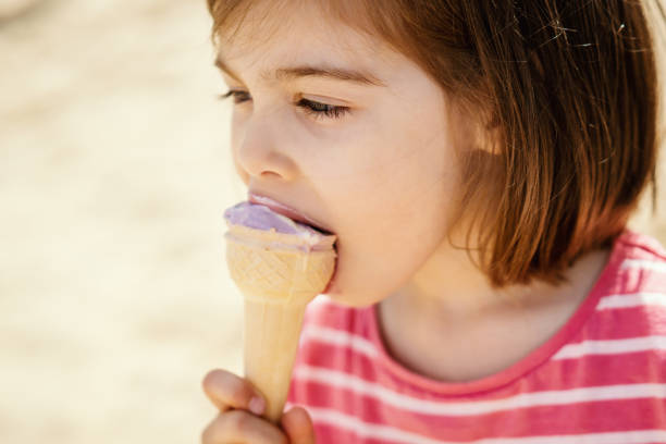 istock little girl eats ice cream sitting on the playground 961172480