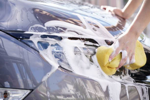istock women washing a soapy grey car with a yellow sponge. 961178576