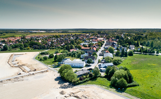 Aerial view from the construction site of a new development area to the old village centre of a suburb near Wolfsburg