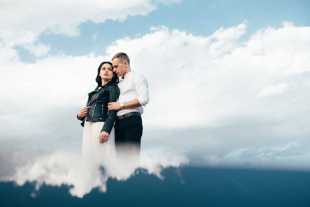 istock Beautiful romantic couple in love standing over blue sky. 961183078