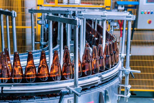 стеклянная бутылка производственной линии на заводе - bottling plant bottle filling production line стоковые фото и изображения