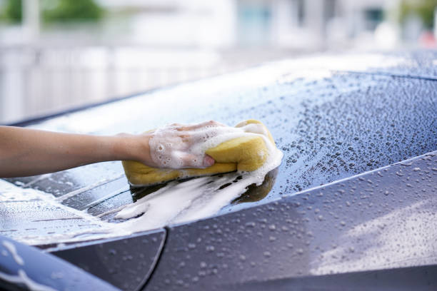 istock women washing a soapy grey car with a yellow sponge. 961188858