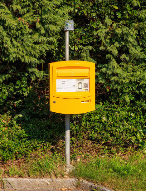 Wallisellen, Switzerland - 23 September, 2017: a yellow letter box of the Swiss Post in front of green plants. The Swiss Post is the national postal service of Switzerland, it is a public company owned by the Swiss Confederation.