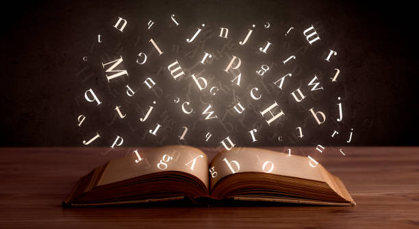 istock Glowing alphabet letters coming out of an open book 961207094