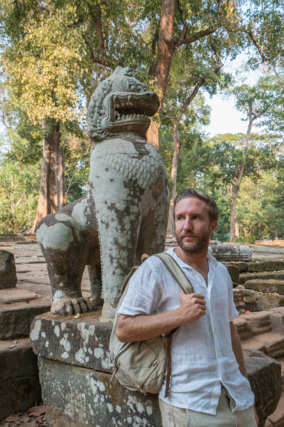 istock Young man contemplating ancient temple in Cambodia 961208440