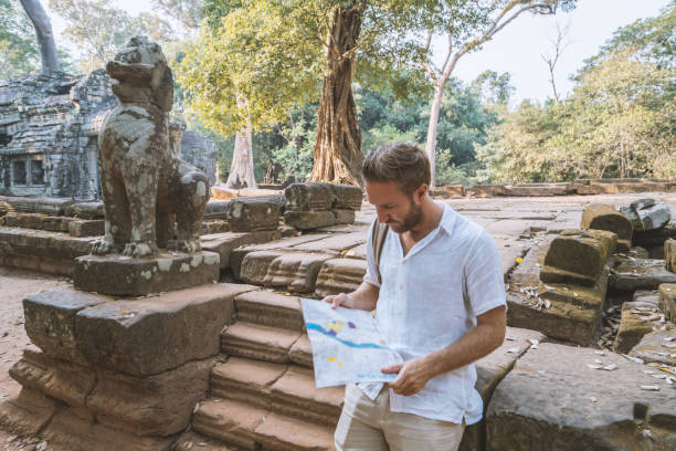 istock Tourist male checking map in ancient temple 961209074