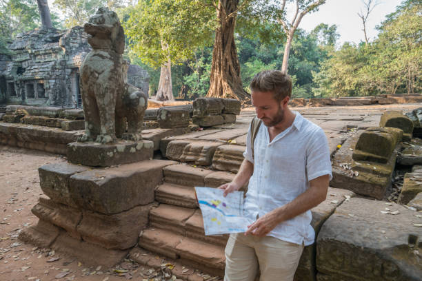 istock Tourist male checking map in ancient temple 961209206