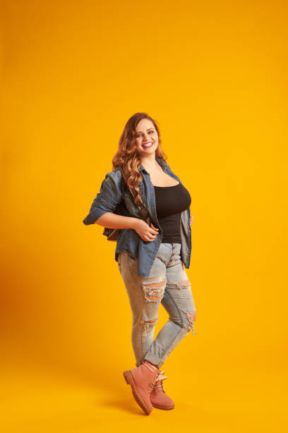 istock Candid curvy girl in denim jacket holding backpack and looking a 961210342