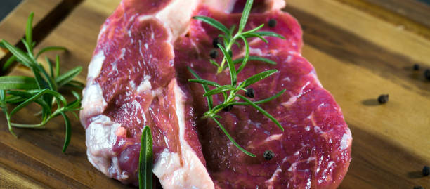 istock Raw beef steak on a wooden table. 961210348