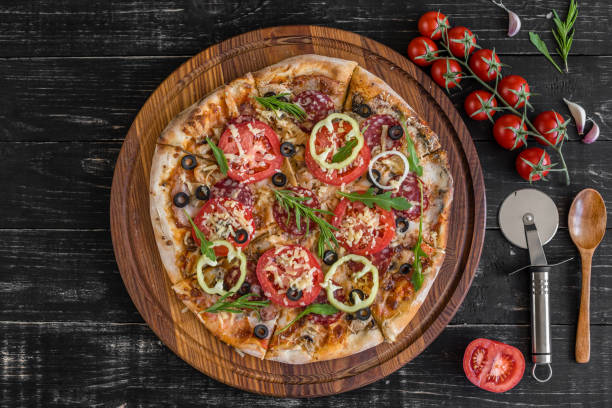 istock Vegetables, mushrooms and tomatoes pizza on a black wooden background 961217082