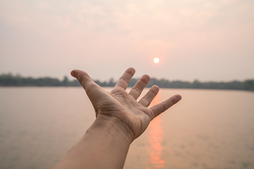 Pov of human hand stretching towards the sun, Energy people environment travel concept Siem Reap, Asia.