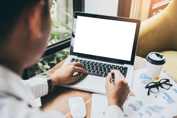 istock Business man hands holding pen and using laptop with blank screen on desk in cafe. 961222796