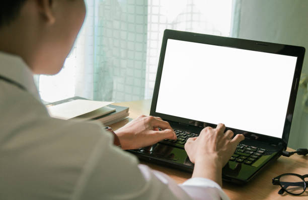 istock Business man sitting using laptop with blank screen on desk in office at home 961223272