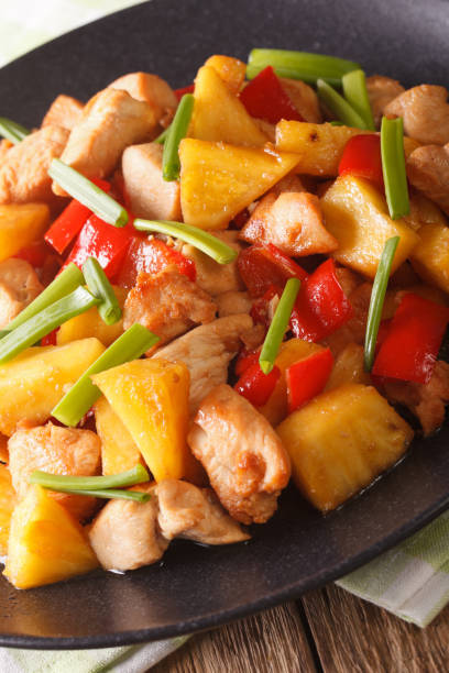 istock fried chicken with pineapple in sweet and sour sauce close-up. Vertical 961231280