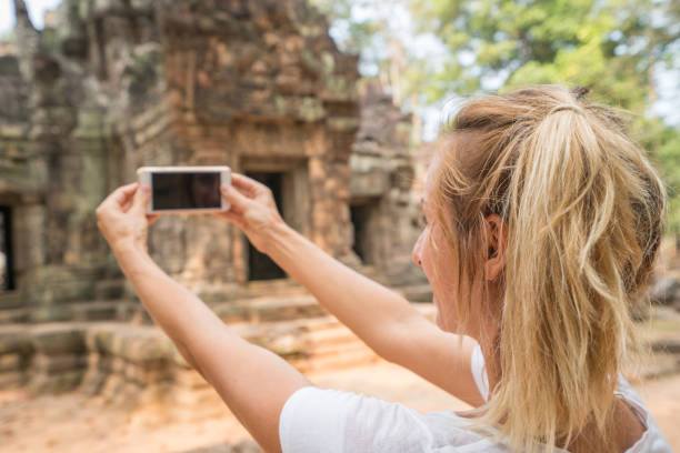istock Tourist female exploring ancient temples and taking smart phone pictures 961232680