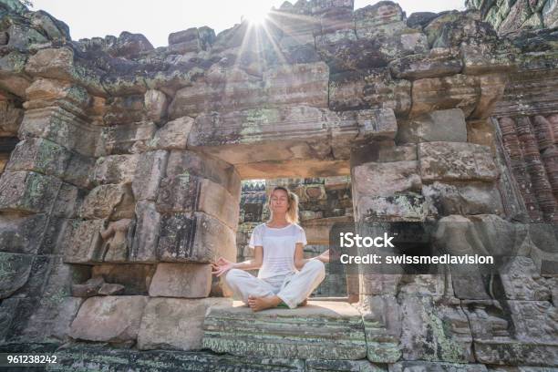 Young Woman Exercising Yoga In Ancient Temple Sitting On Old Ruins Window Sunlight Passing Through And Relaxing With Some Meditation Concept Of People With Healthy Lifestyles And Wellbeing And Travel Stock Photo - Download Image Now