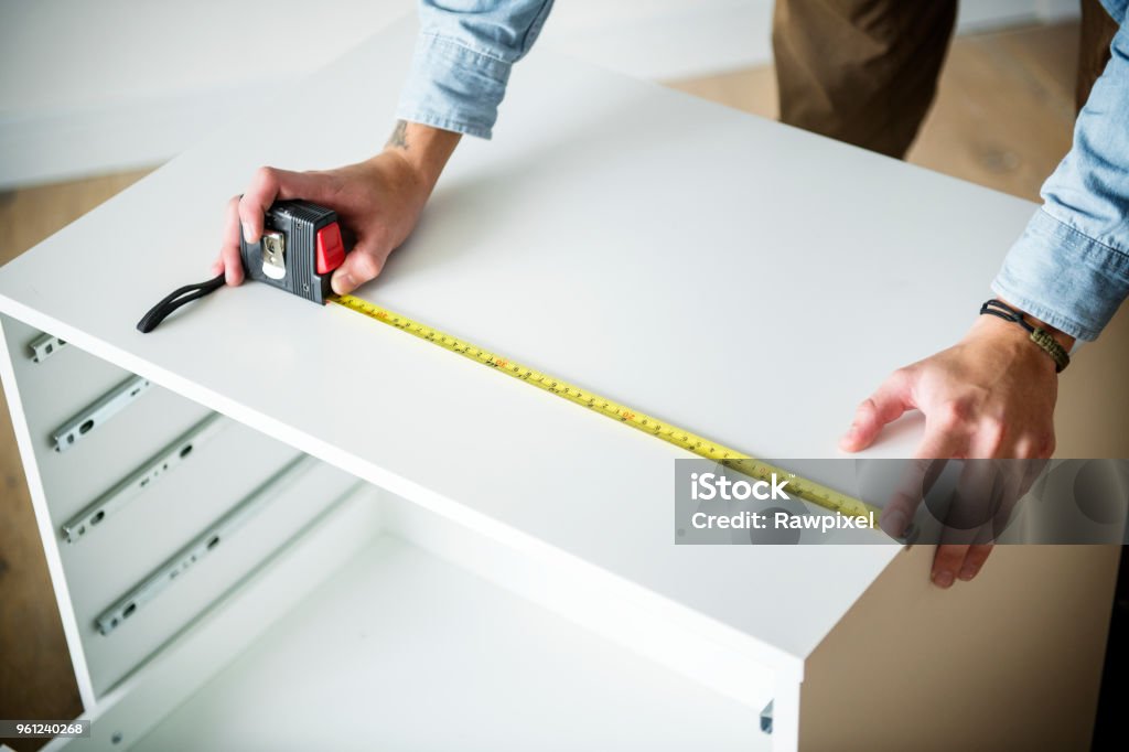 Man measuring the cabinet Furniture Stock Photo