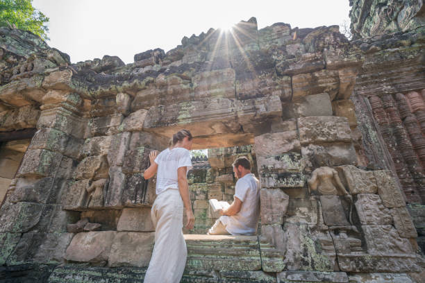 istock Young couple reading travel guidebook while visiting ancient temple , people travel destinations discovery togetherness concept 961242372