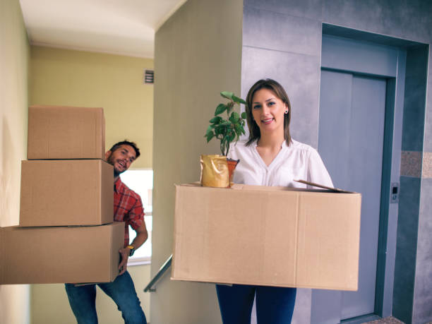 istock Couple Moving Into New Home Carrying Box Upstairs 961243274