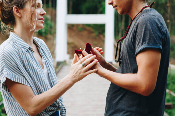 istock Man proposing to his happy girlfriend outdoors 961249666
